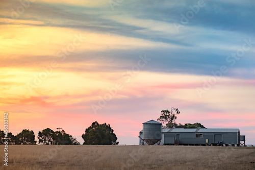 Sunset over sheep farm with sheering shed in outback Victoria Australia.