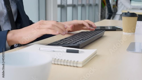Business man in suit outfit working in front of computer with smart and confident typing on keyboard in modern office