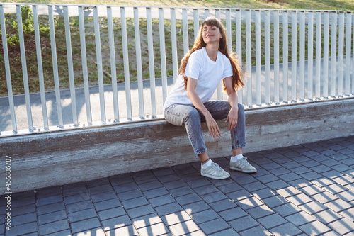 Young female with long wears hair white t-shirt.