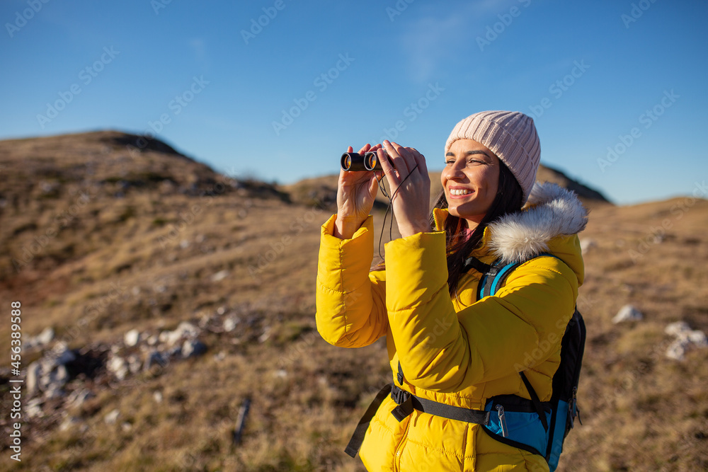 Female hiker using binocular to admire view