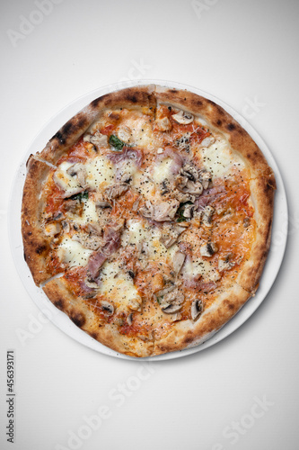 top view of italian pizza with ham, mushrooms and cheese on white background