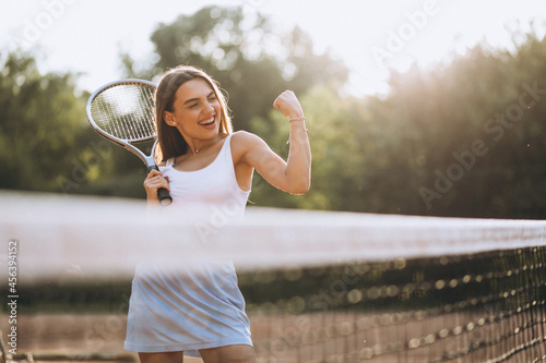 Young woman playing tennis at the court © Petro