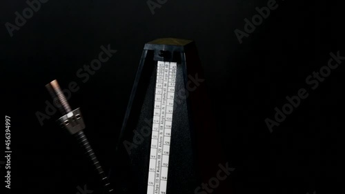Close-up metronome at 72 BPM against black background photo