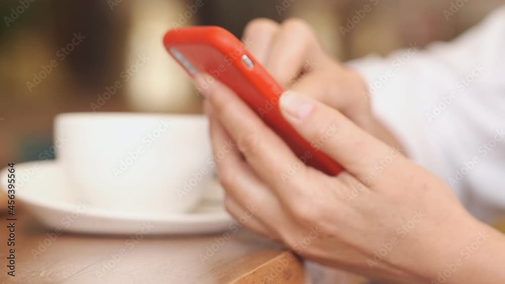 Closeup business woman typing message on mobile phone at restaurant. Close up young woman hands using smartphone . Closeup business woman typing message on mobile phone at restaurant. Close up young woman hands using smartphone .