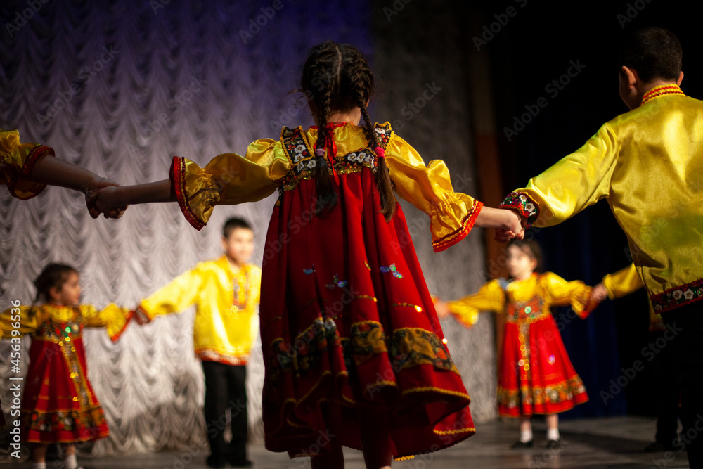 Children in folk costumes lead a round dance.
