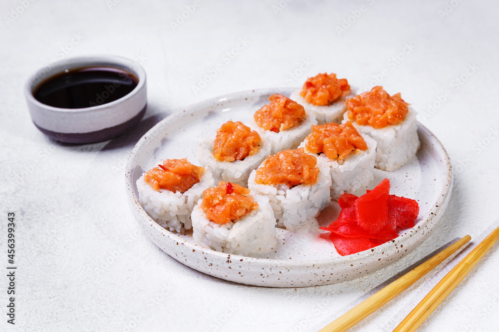 sushi rolls with salmon and hot pepper ginger and soy sauce on a white background sushi rolls with salmon and hot pepper ginger and soy sauce on a white background