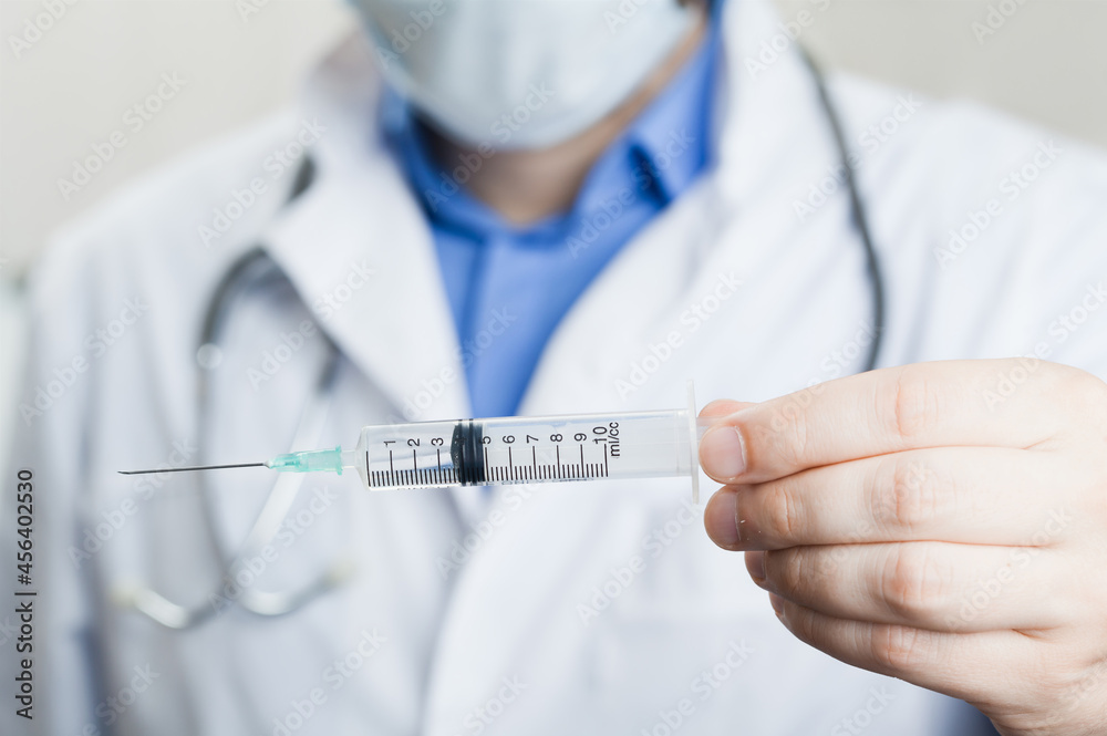 Doctor holding a syringe with vaccine against corona virus. Doctor holding a syringe with vaccine against corona virus.