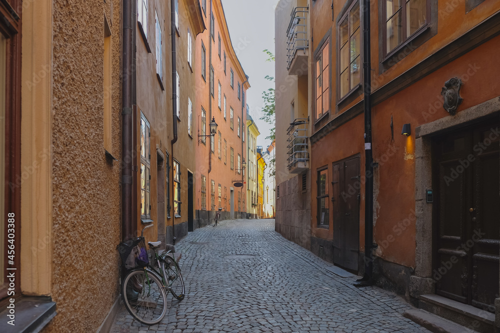 A narrow street iwith cobblestone pavement n the old part of Stockholm city - Gamla Stan. The bikes are parked on the site and the windows face each other