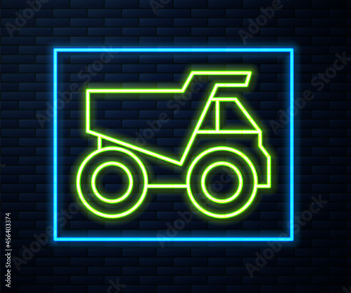 Glowing neon line Mining dump truck icon isolated on brick wall background. Vector