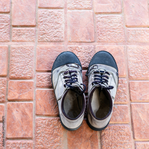 Vintage old shoes, old sneakers on tiled floors.