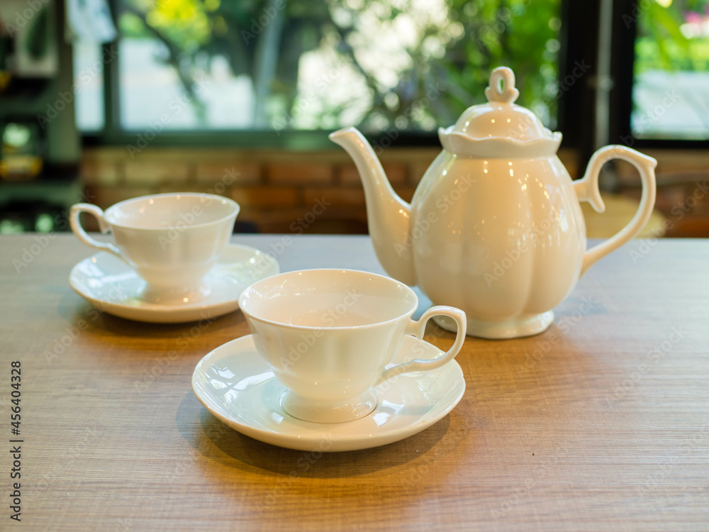 coffee cups and teapot on a wooden table in a coffee shop. coffee cups and teapot on a wooden table in a coffee shop.