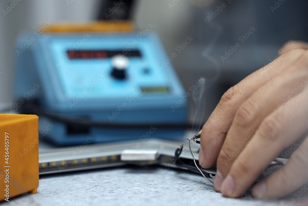 Wires being soldered together with a soldering iron. Melting solder