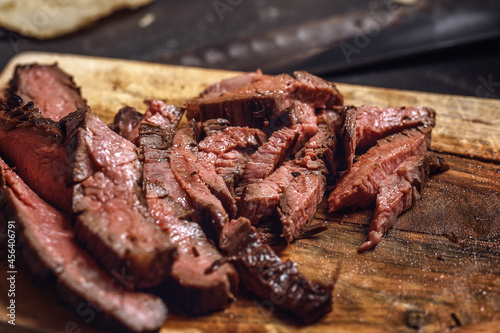 Tableau sur toile Sliced grilled flank steak on wood board