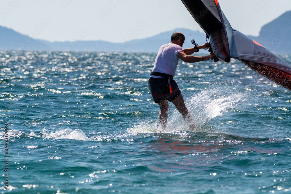 Naklejka premium Hyeres, Almanarre beach, France, July 10, 2021. Extreem water sport - wing foil, kite surfing, wind surfindg, windy day on Almanarre beach near Toulon, South of France