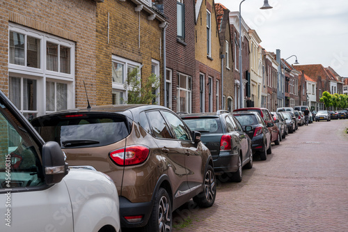 Street parking of cars in old Dutch town Zierikzee with old small houses and streets