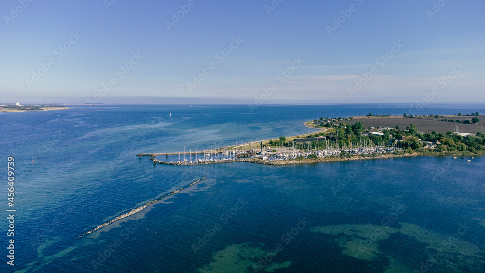 Kleine Hafenstadt mit Hafen und Segelbooten an der Ostsee mit blauem Wasser und grüner Natur