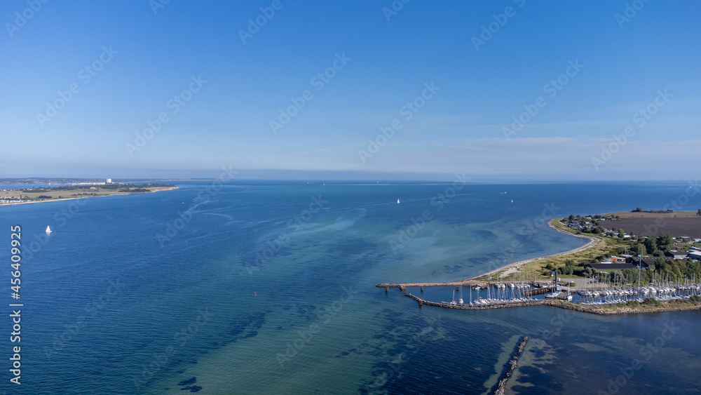 Kleine Hafenstadt mit Hafen und Segelbooten an der Ostsee mit blauem Wasser und grüner Natur