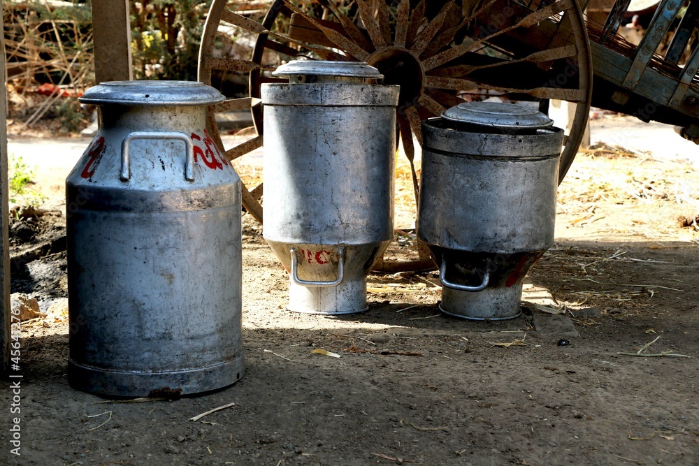 Landscape view of traditional milk container in shed and bullock cart behind in village Landscape view of traditional milk container in shed and bullock cart behind in village