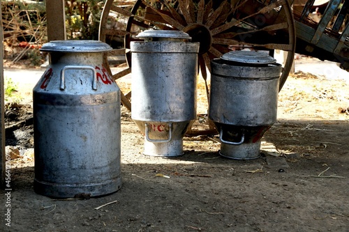 Landscape view of traditional milk container in shed and bullock cart behind in village