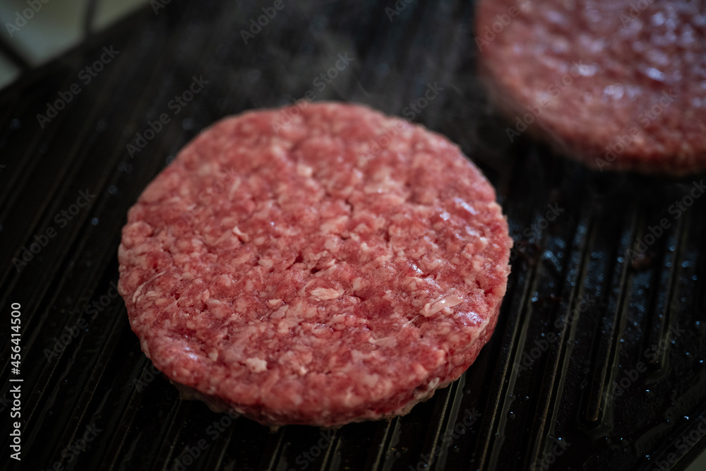 cooking beef patties on grill