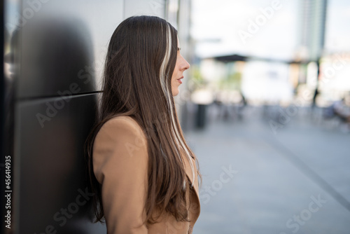 Businesswoman leaning against a wall