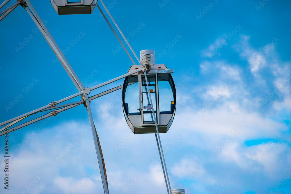 Ferris wheel on the background of a blue sky with clouds. Close-up. Part of the wheel. The cabin . Ferris wheel on the background of a blue sky with clouds. Close-up. Part of the wheel. The cabin .