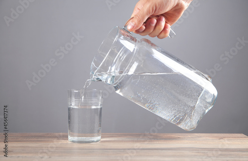 Male hand pouring water into glass. Healthy drink