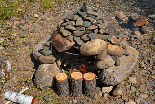 Russia. Chita region. The initial stage of preparing a hiking bath "in a black way". After warming up the stones, the remnants of hot coals are removed and a special tent is installed on top.