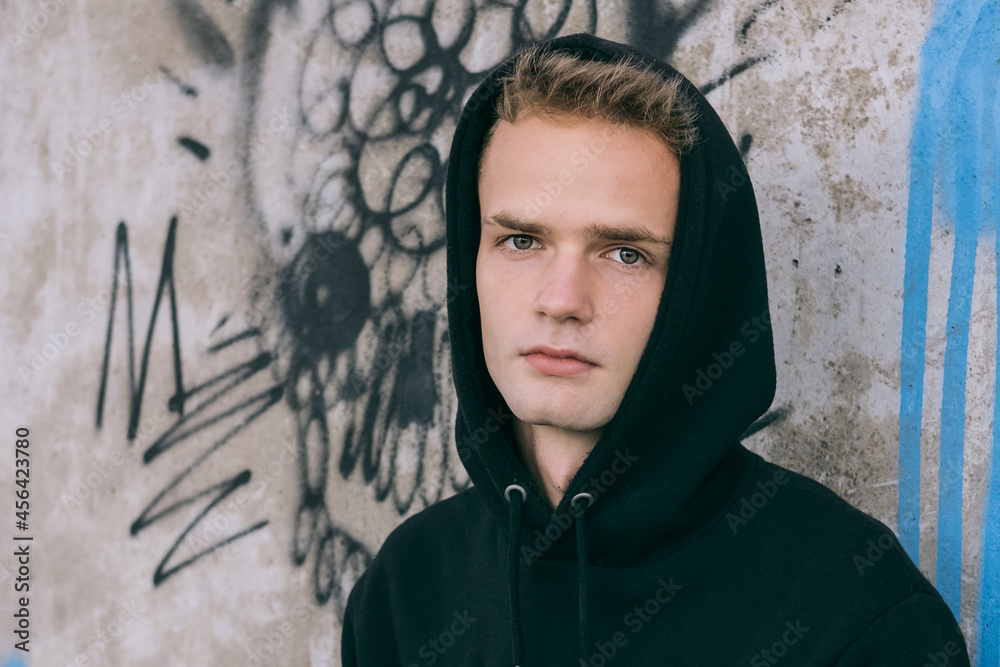 portrait of sad handsome teenager in hoodie