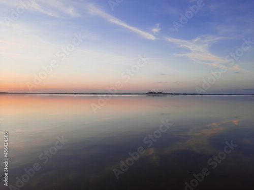 Shatsky Lakes. Ecotourism. Shatsk National Natural Park. Landscape of the setting sun on the lake. Blue skies and gentle water with sun tints. The mirror water of the lake reflects the sky.