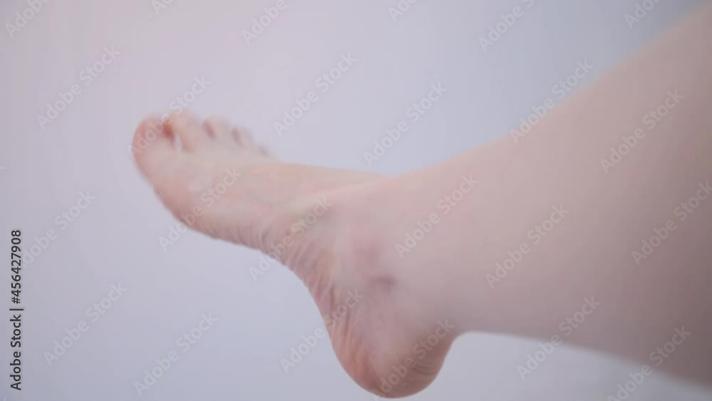 Woman's foot close up. The girl kneads her leg. Circular motion in the ankle. Convulsions, stagnation of blood circulation. Warm up. Useful exercises for the legs. Arch of the foot without signs of Woman's foot close up. The girl kneads her leg. Circular motion in the ankle. Convulsions, stagnation of blood circulation. Warm up. Useful exercises for the legs. Arch of the foot without signs of