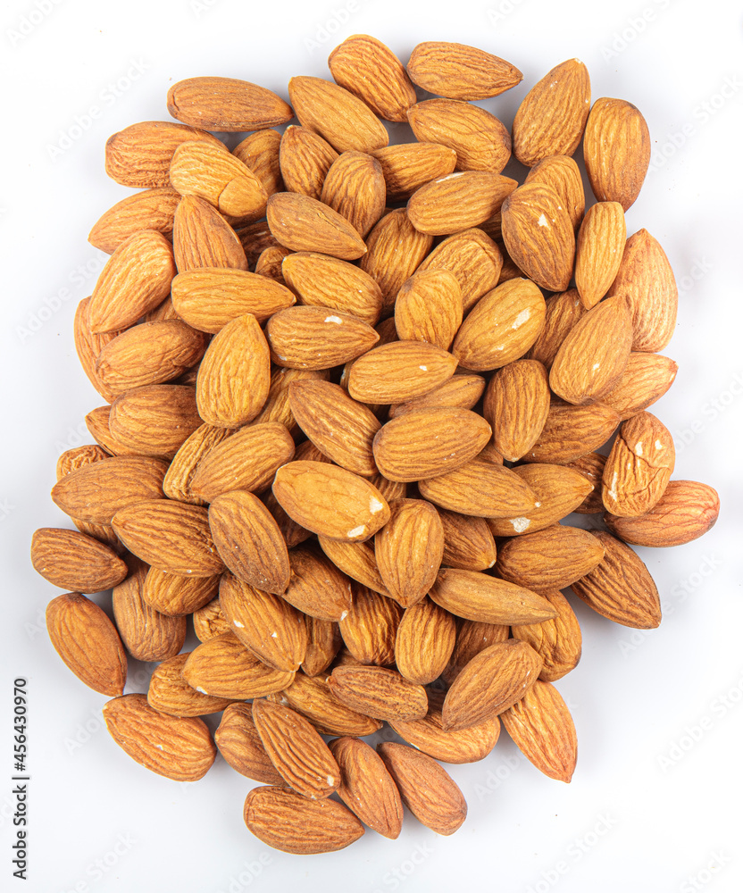 Delicious sweet almonds lie in a large heap, nuts close-up. Fresh nuts, almonds as a background.