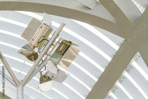 Directional metal lamps on the ceiling of a metal walkway