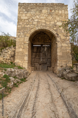 Wooden gate in the tower of an antique stone fortress