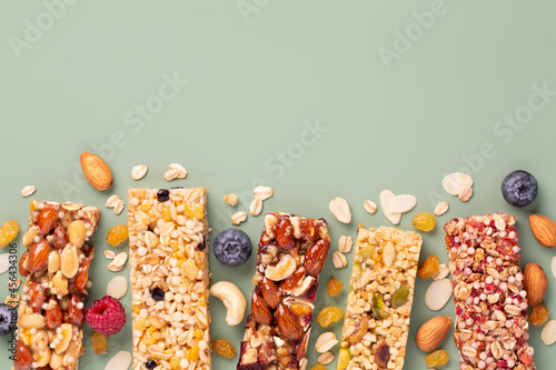 Granola bars. Healthy energy bars made of cereals, berries, nuts and fruits on a light green background. Space for the text. Top view. Muesli.