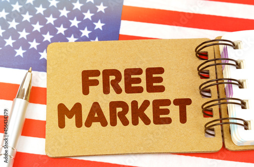 On the US flag lies a notebook with the inscription - free market