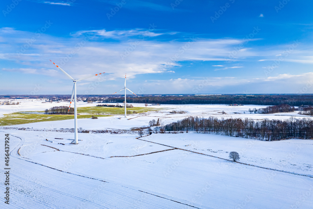 Wind turbines on snowy field. Alternative energy in winter Wind turbines on snowy field. Alternative energy in winter