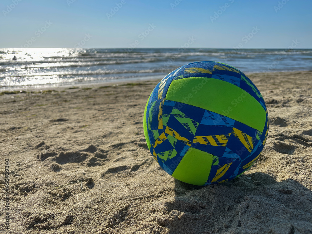 Green and blue ball on the beach.