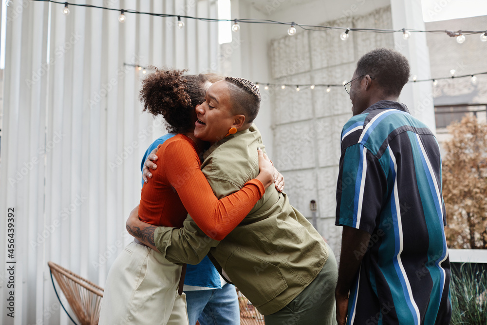 Obraz premium Multi-ethnic group of modern young people greeting each other at rooftop party, copy space