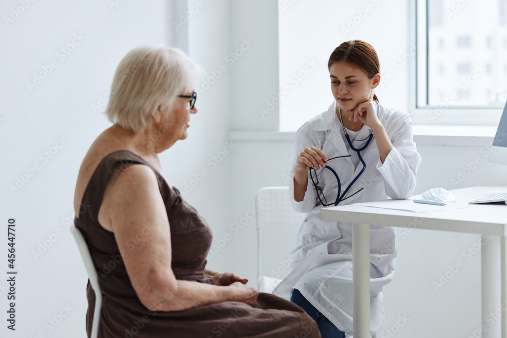 Obraz premium doctors in the medical office talking to an elderly woman health diagnostics