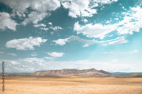 Plain and simple harvested field under cloudy blue sky with trendy colors. Usable for background.