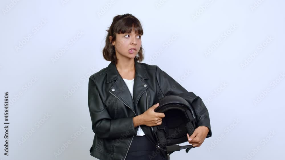holding a motorcycle helmet having doubts and questioning an idea over isolated background holding a motorcycle helmet having doubts and questioning an idea over isolated background
