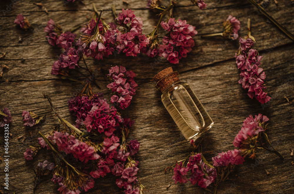 Oil bottle. Wooden table. Oil. FLowers. Oil bottle. Wooden table. Oil. FLowers.