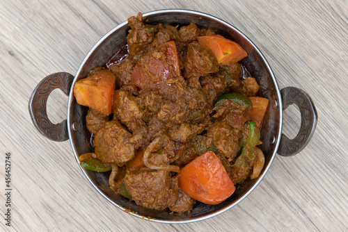 Overhead view of bhuna flavored lamb meat in a bowl from Indian restaurant cooked and seasoned perfectly