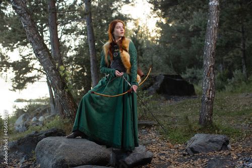 Konstfotografi Beautiful red-haired girl-archer of Middle Ages in outdoor