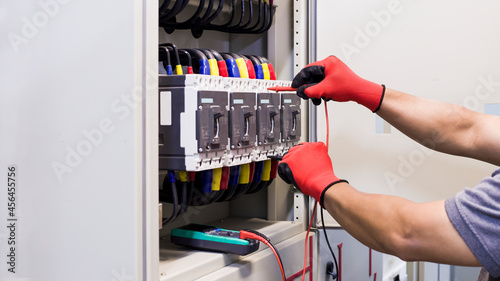 Electrical engineer tests the operation of the electric control cabinet on a regular basis for maintenance. 