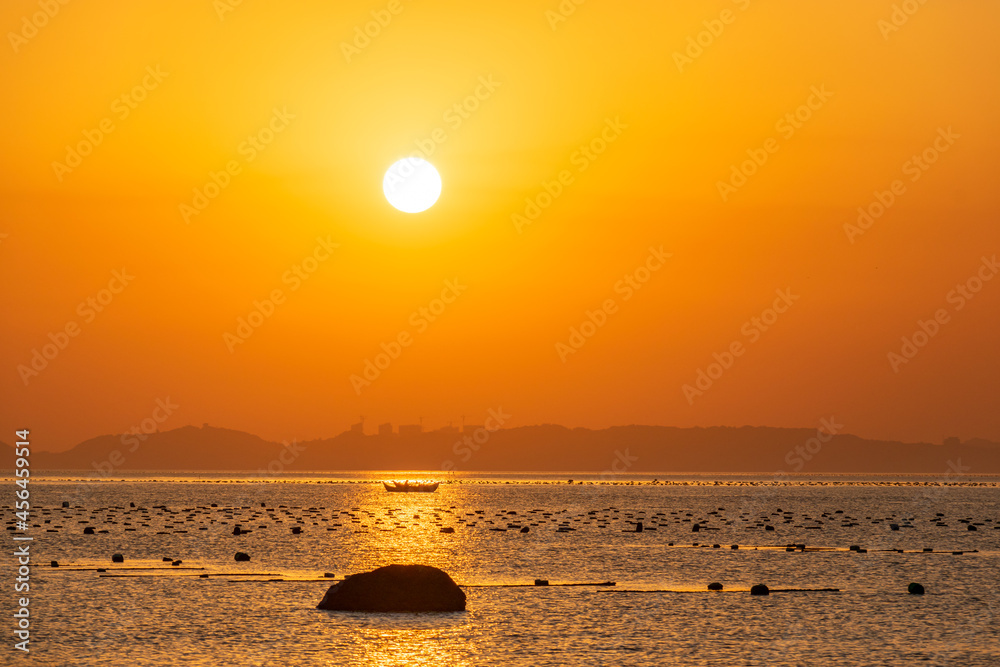 The sea under the setting sun is golden, and the sun is like an egg yolk