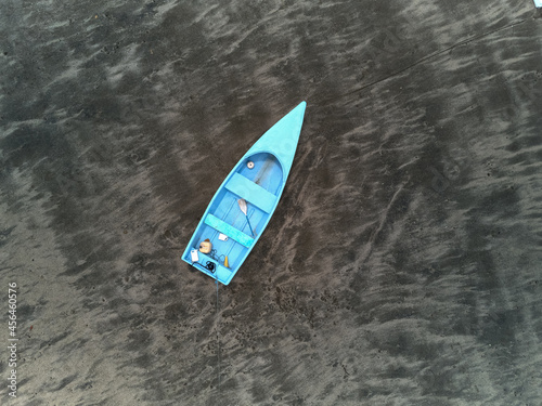 Blue fishing skiff lays on a sandy beach at low tide near Paquera Costa Rica on the Gulf of Nicoya in this aerial drone image © Jorge Moro