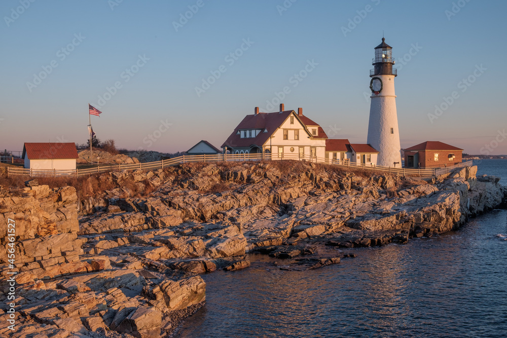 First Rays of Sunlight strike the rocks making them glow orange-red at the Portland Head Lighthouse on Cape Elizabeth.