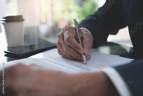 Businessman signing business contract with a pen at office